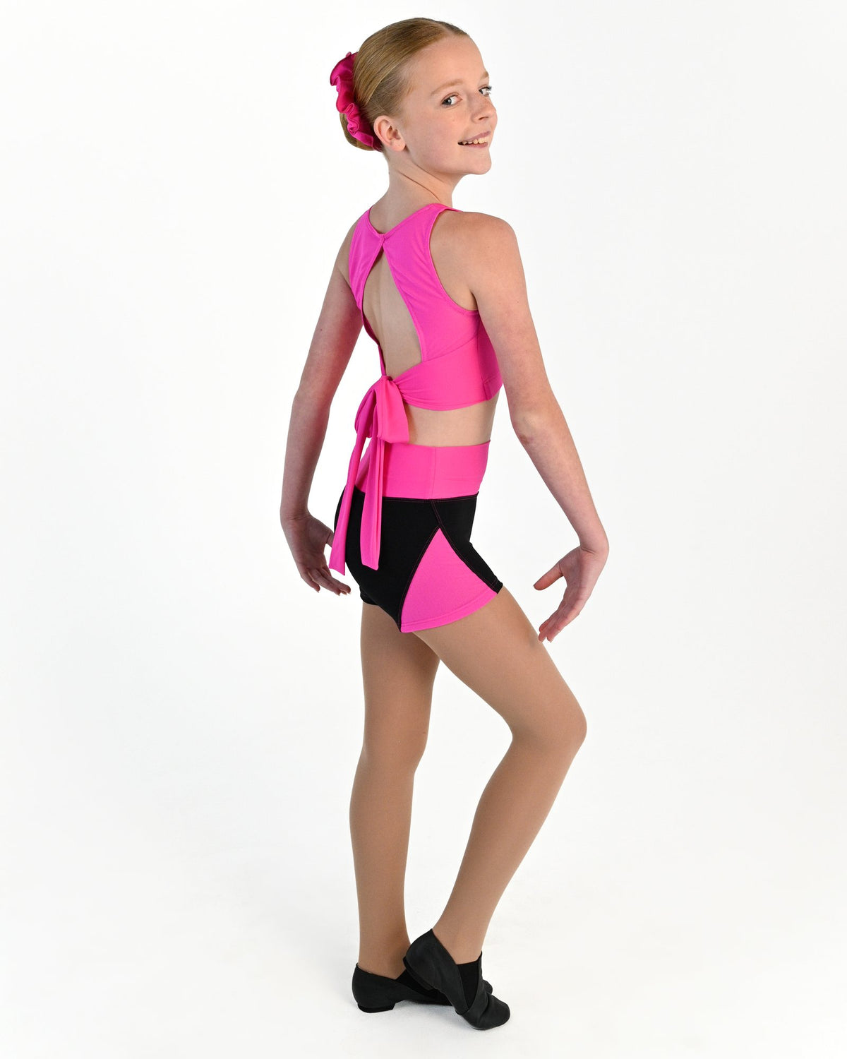 Young dancer wearing the Electra mesh panel high waisted dance shorts in Electric Pink, alternate view