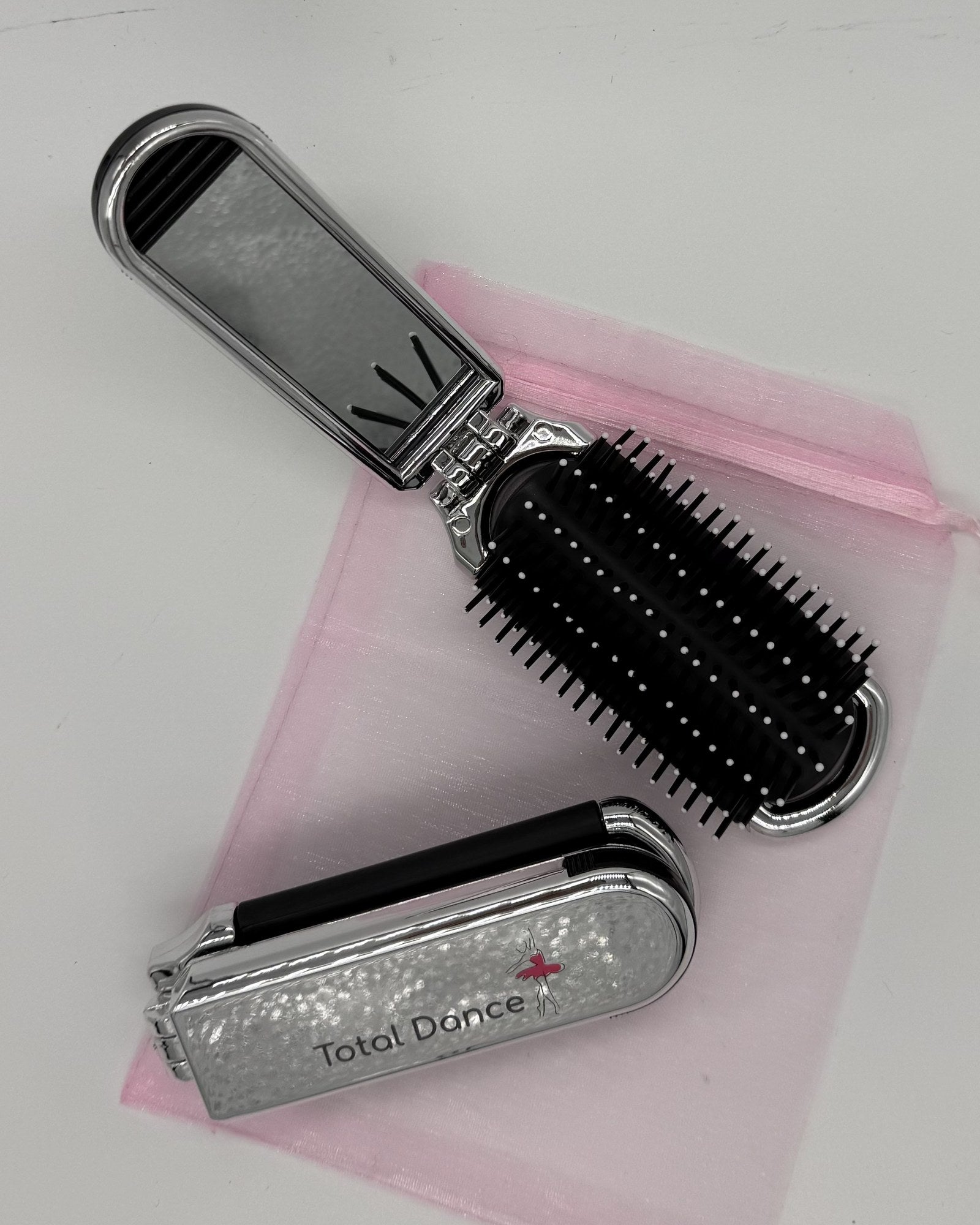 Total Dance foldable hair brush folded and open views on pink organza travel pouch, silver metallic finish with Total Dance ballerina logo