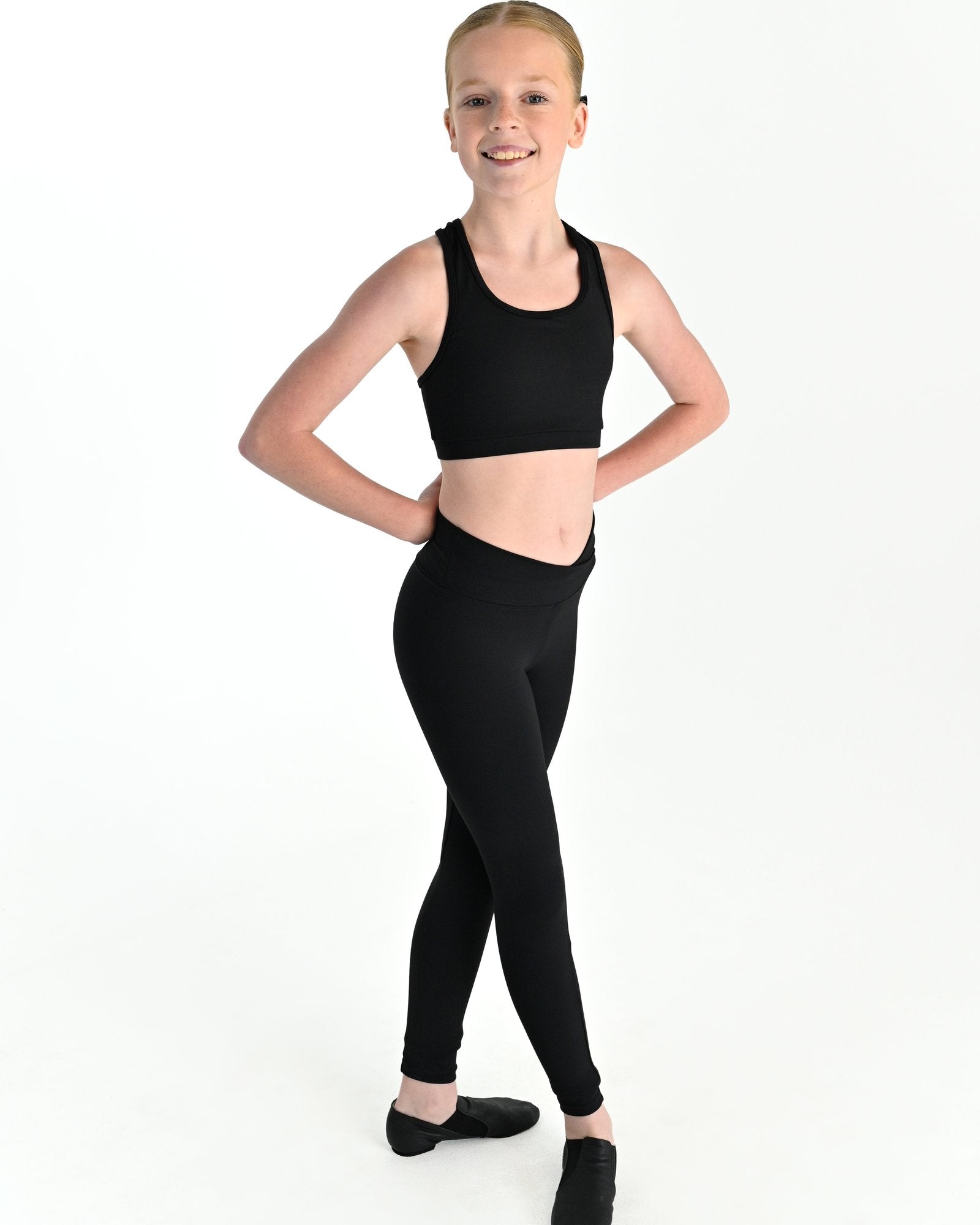 Young dancer wearing the Violet crossed back dance crop top with contrast binding in Black